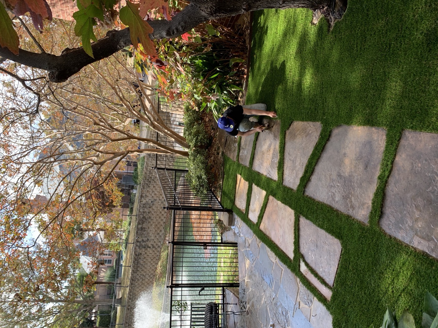 Flagstone path through turf with a garden pond