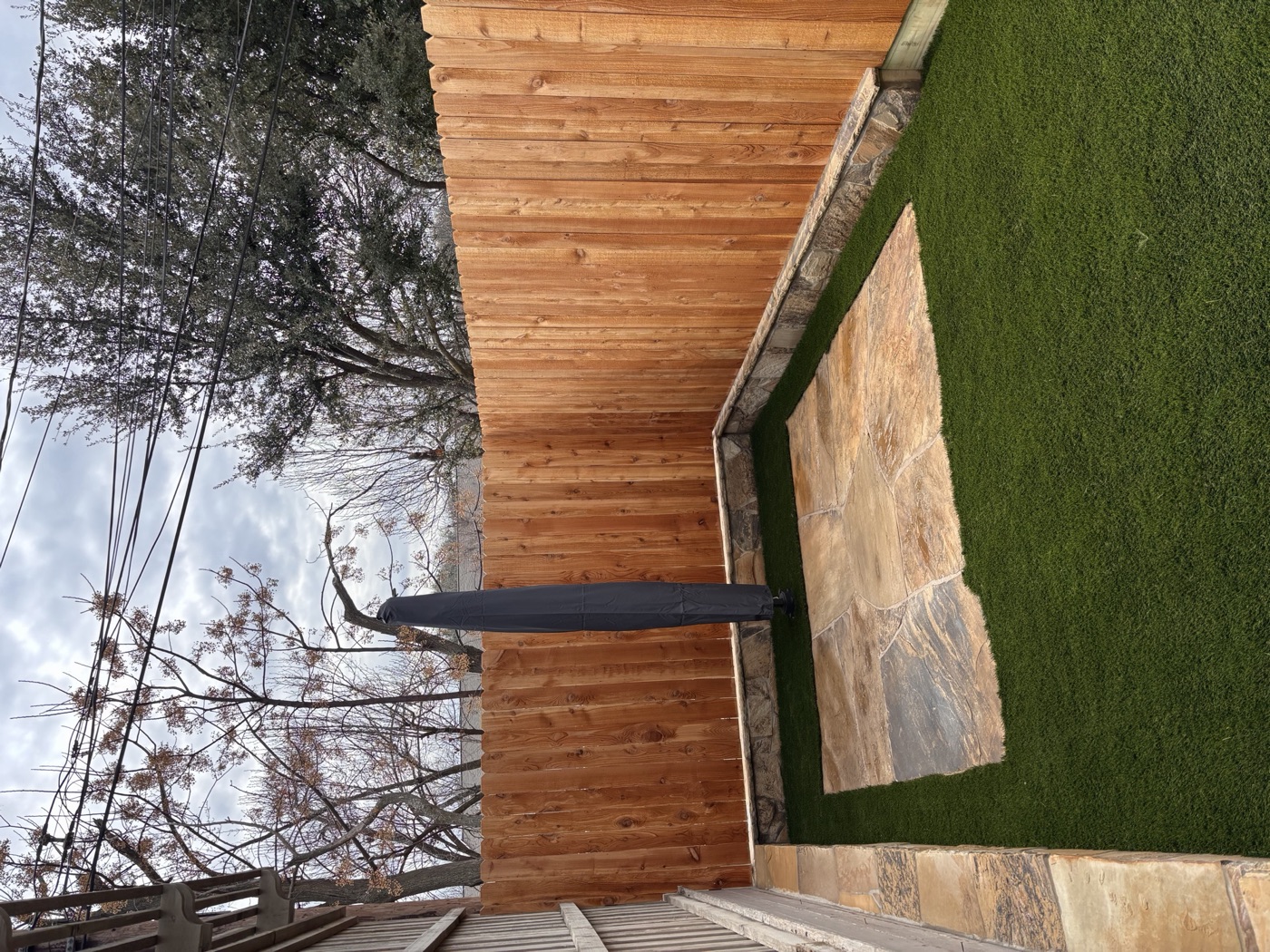 Flagstone patio framed by a new cedar privacy fence