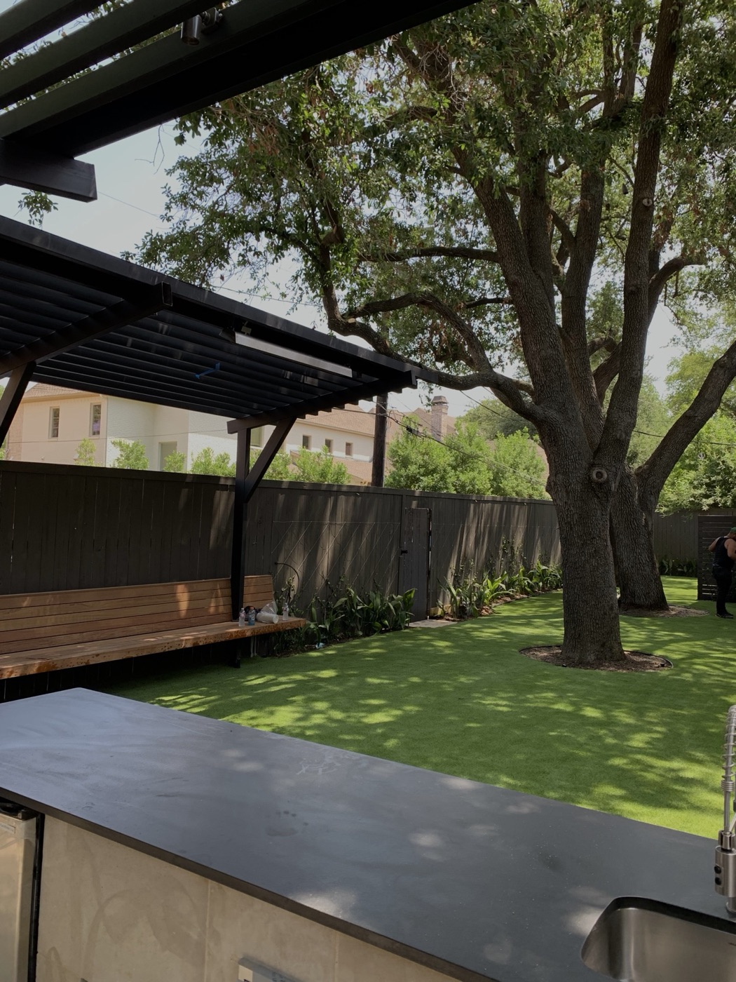 Covered patio and turf lawn beneath a live oak